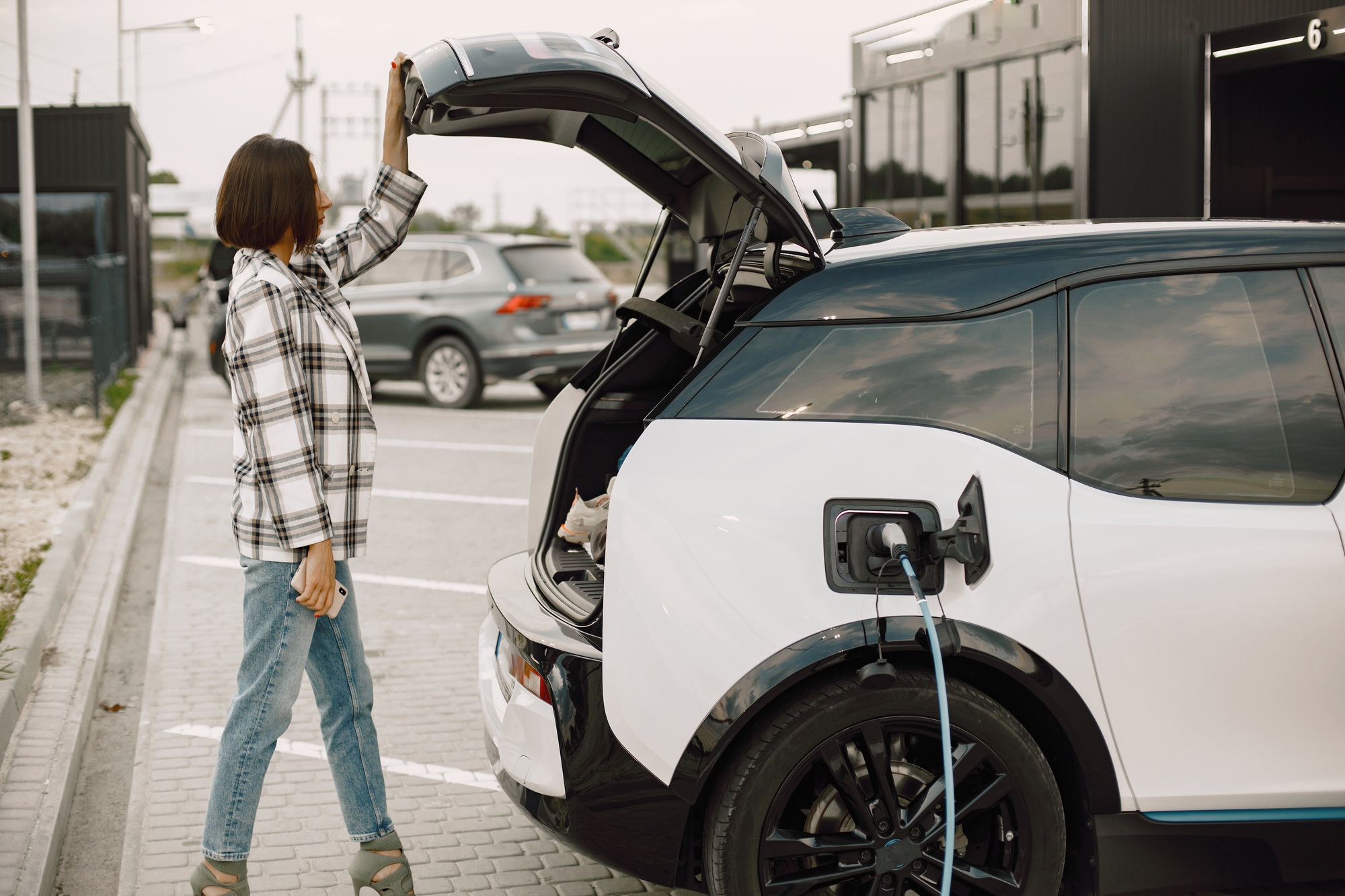 Businesswoman on the electric cars charge station